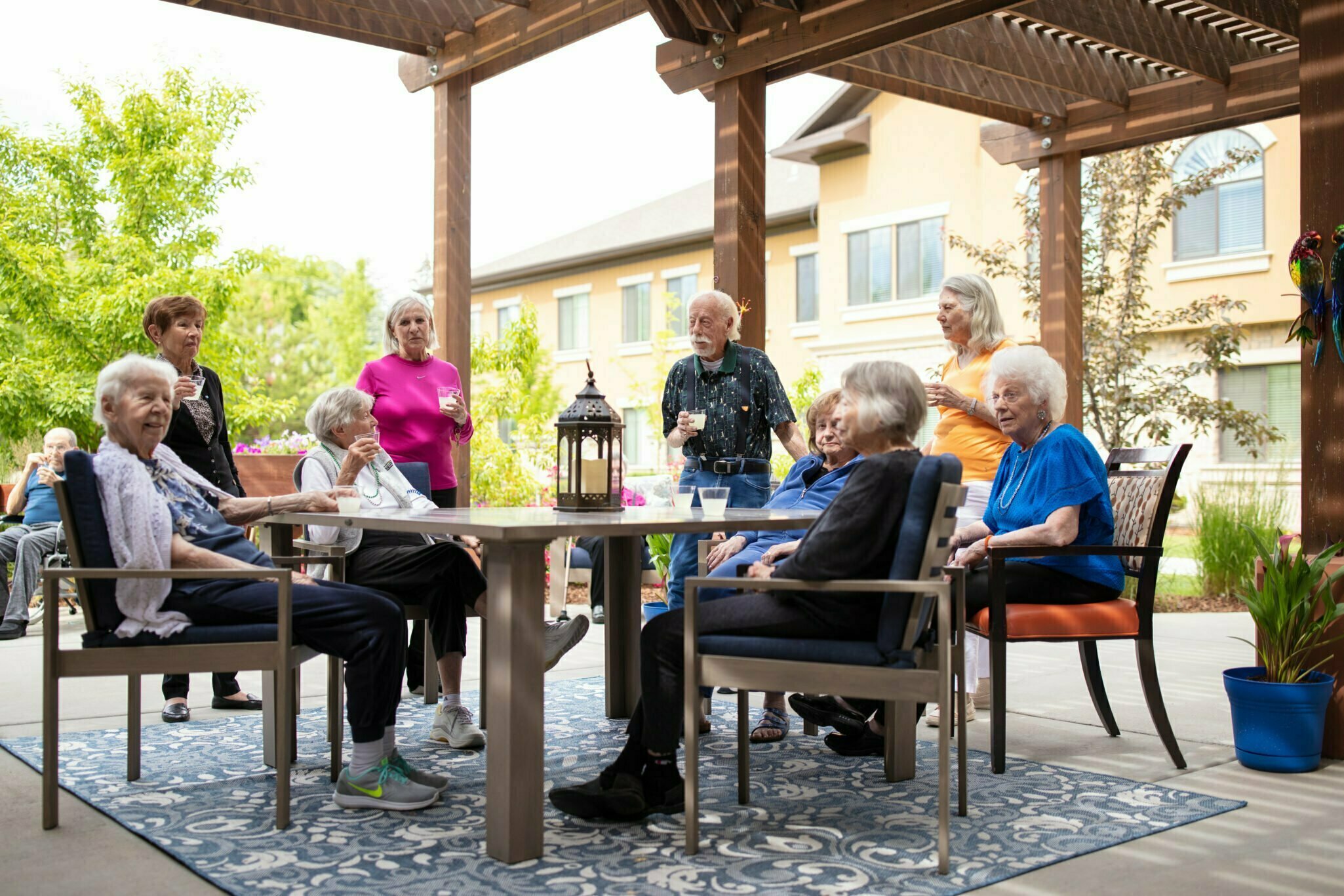 Senior living residents sitting around outdoor patio