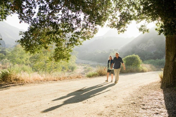 A couple go for a walk outside on a rural countryside trail