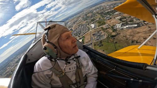 World War II veteran flies in a biplane.