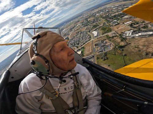 World War II veteran flies in a biplane.