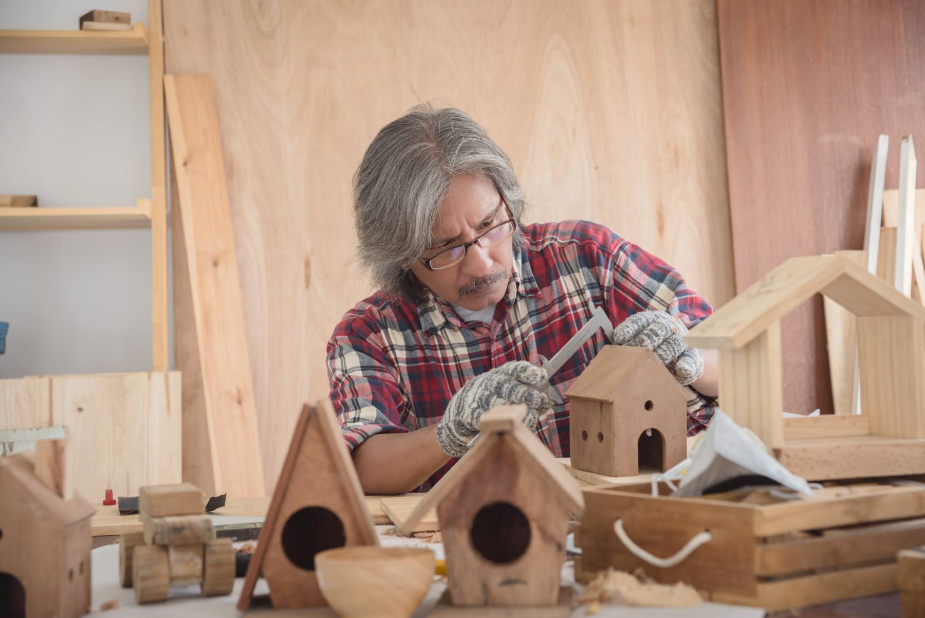 A senior man works on Christmas woodworking projects